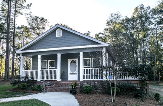 Small blue gray mobile home with a front and side porch.