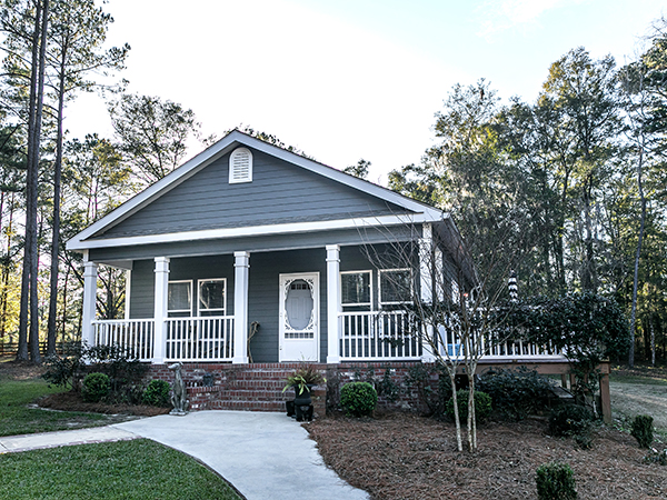 Small blue gray mobile home with a front and side porch.