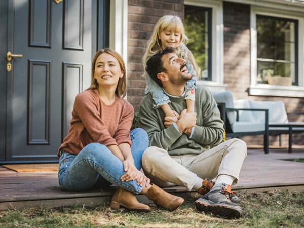 couple with child in front of home