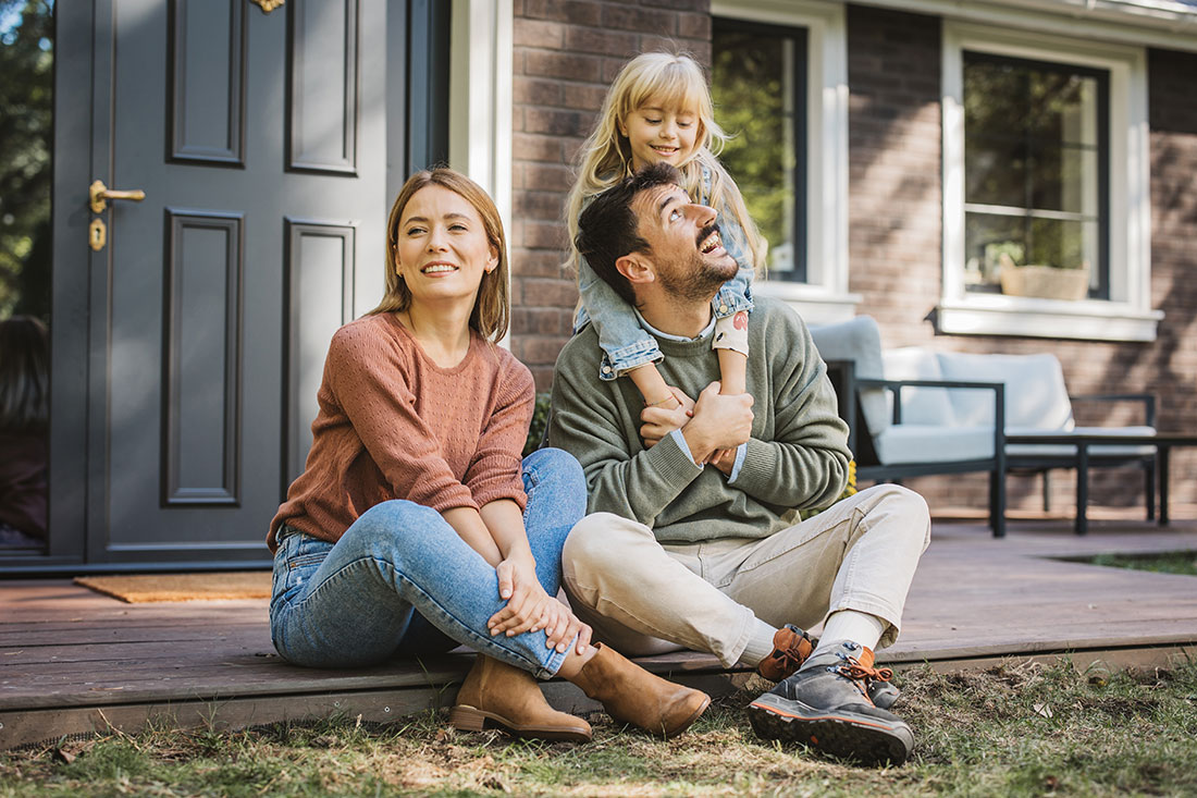 couple with child in front of home