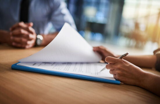 Close up shot of a man and woman completing paperwork together at a desk